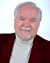 Commercial Headshot Smiling Burgundy jacket light gray turtleneck